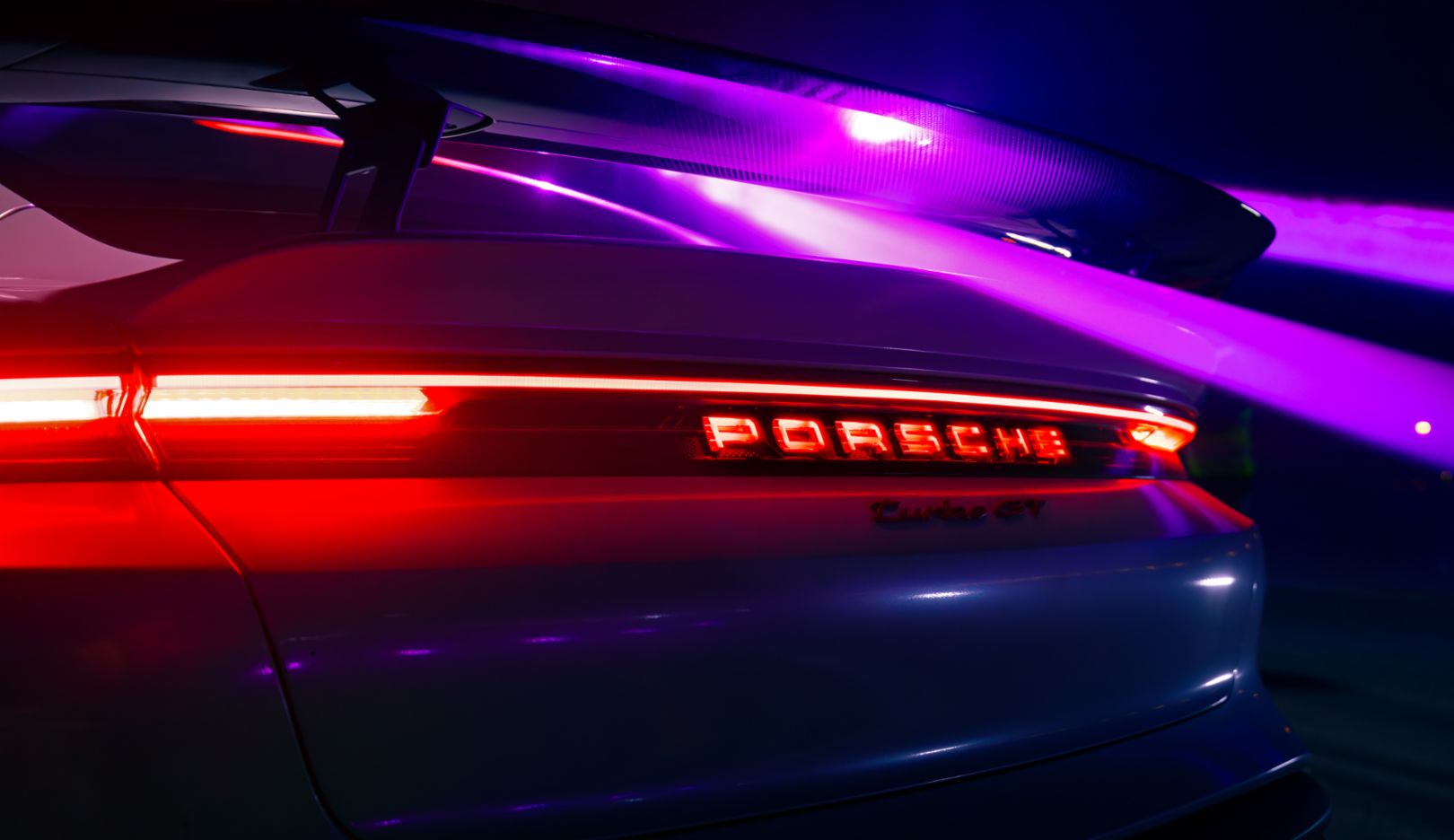 Os detalhes do veículo, como a traseira do Taycan Turbo GT, brilham à luz do cenário.