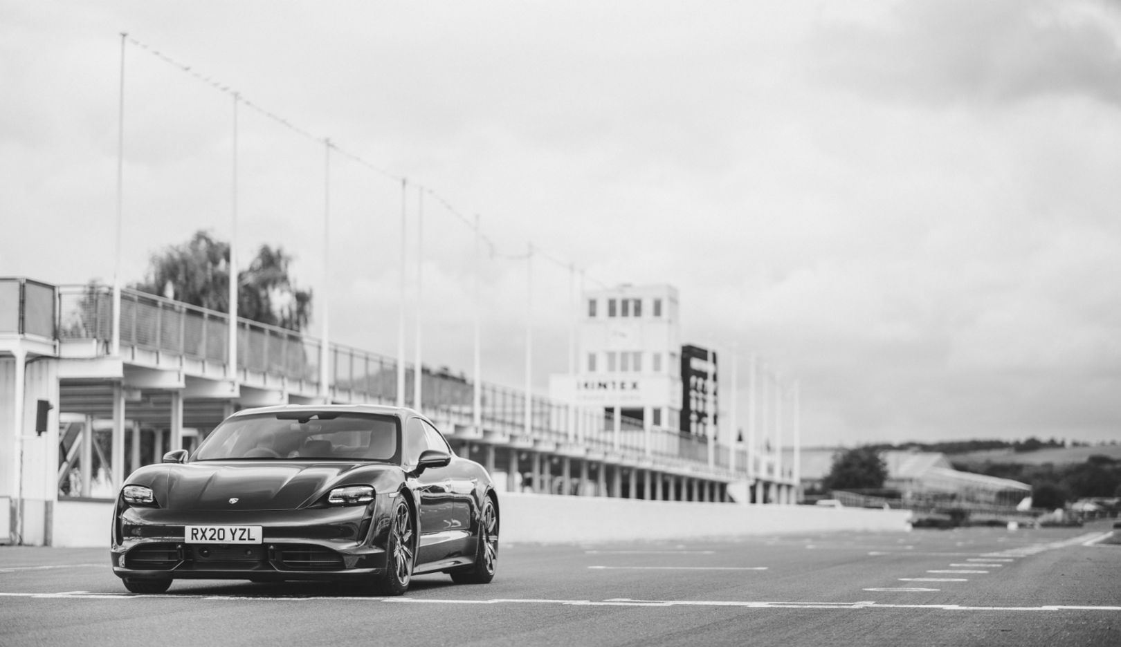Reduced to shading: the dark Taycan in front of a whitewashed racing grandstand. Dramatic, solitary, and thus perfectly suited to this time of distancing.