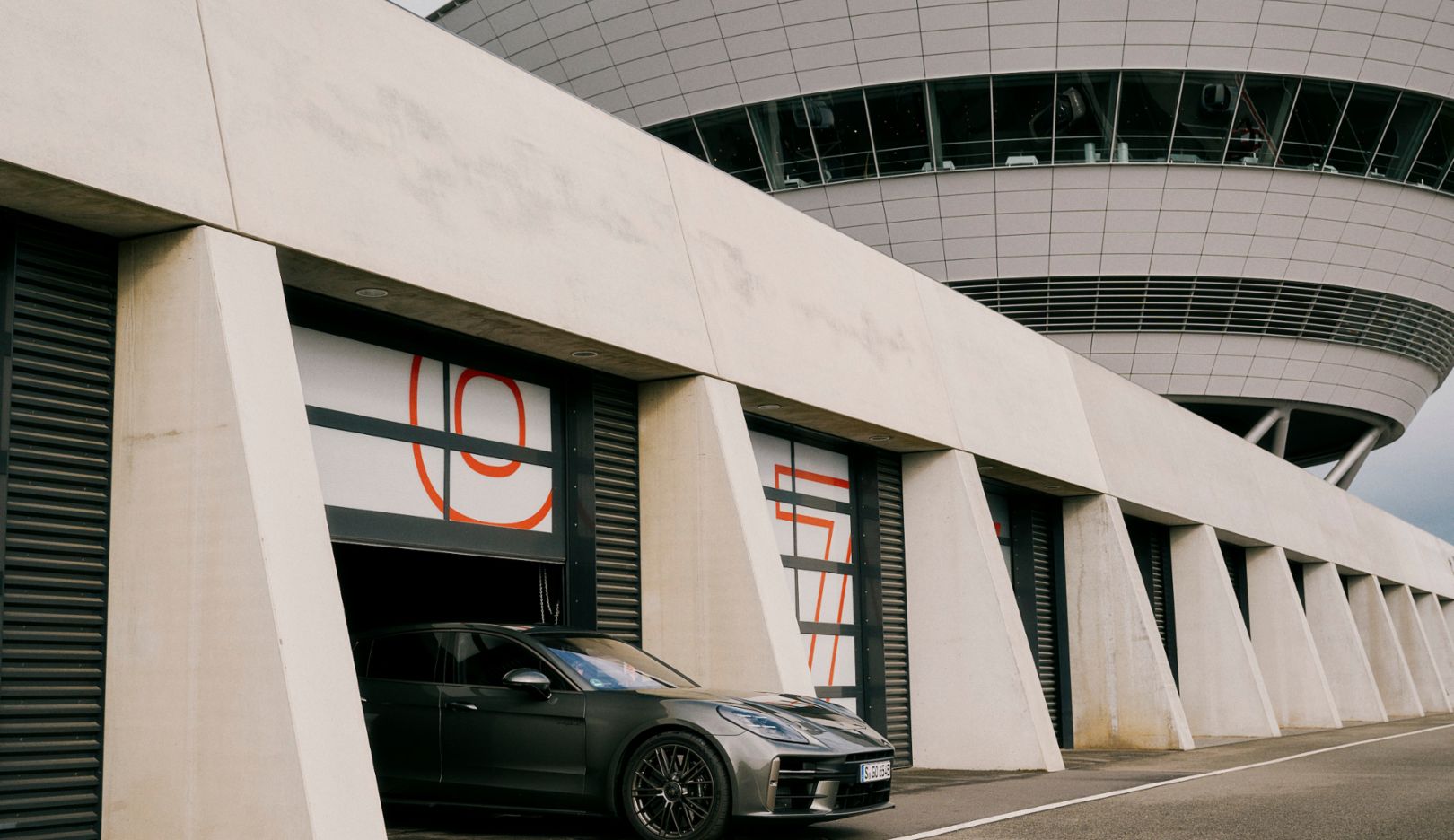 Al borde del circuito de Leipzig, el Panamera Turbo E-Hybrid sale del garaje. Tiene por delante un viaje hacia el pasado de la marca Porsche.