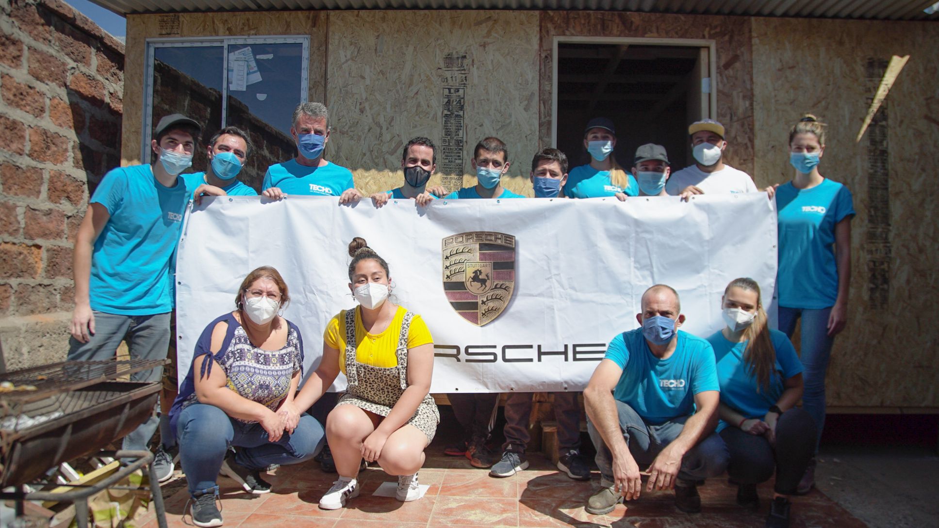 Voluntarios de Porsche y TECHO, al finalizar la construcción