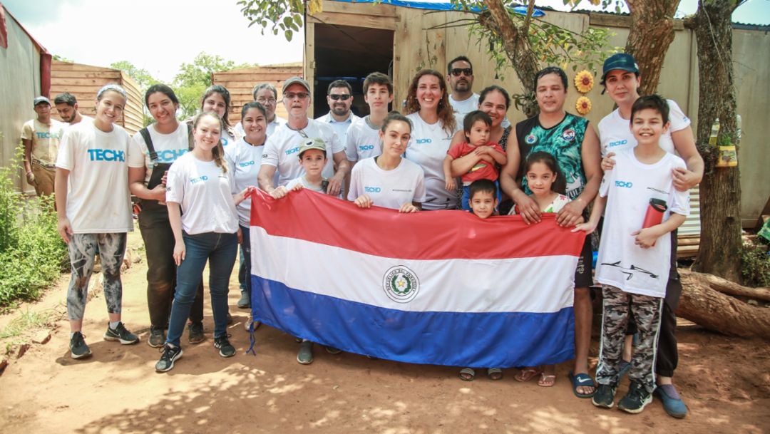 Amancio Benítez (de camiseta verda), junto a su esposa, hijos y los voluntarios de Diesa y TECHO, asentamiento El Triunfo, Paraguay, 2022, Porsche Latin America