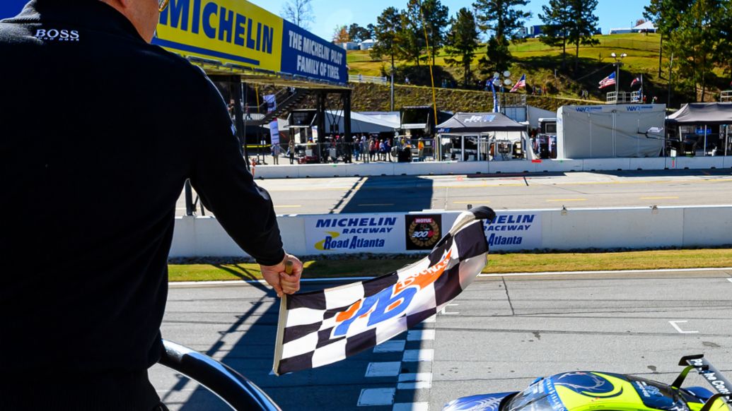 Porsche 911 GT3 Cup - No. 65 Team Hardpoint - Efrin Castro (DR), 2021 Porsche Carrera Cup North America Presented by the Cayman Islands Pro-Am class Champion crosses under the checkered flag thrown by Porsche Motorsport North America President and CEO Dr. Daniel Armbruster, Michelin Raceway Road Atlanta, Braselton, GA., USA, 2021, PCNA
