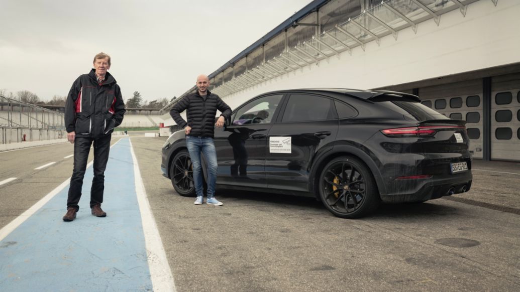 El embajador de la marca Walter Röhrl y el piloto de pruebas Lars Kern (i-d) con el prototipo camuflado del nuevo Cayenne de altas prestaciones en el autódromo de Hockenheim, en Alemania, 2021, Porsche AG