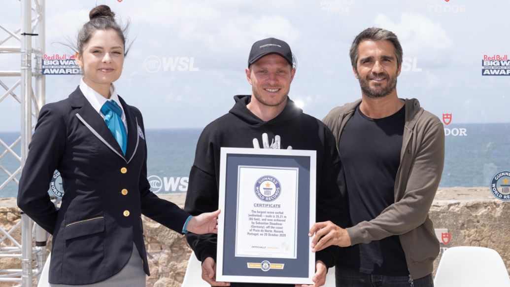 Sebastian Steudtner, en el centro, con el certificado de Guinness World Records, Nazaré, Portugal, 2022, Porsche AG