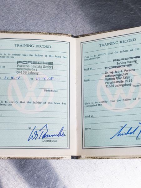 Jack Swint holds his original "training passport," Porsche Restoration Center, Atlanta, 2021, PCNA