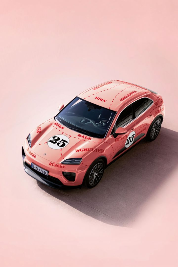 Ein rosa Porsche Macan mit Rennnummer 25 und roten Aufdrucken anatomischer Begriffe steht auf rosa Hintergrund.