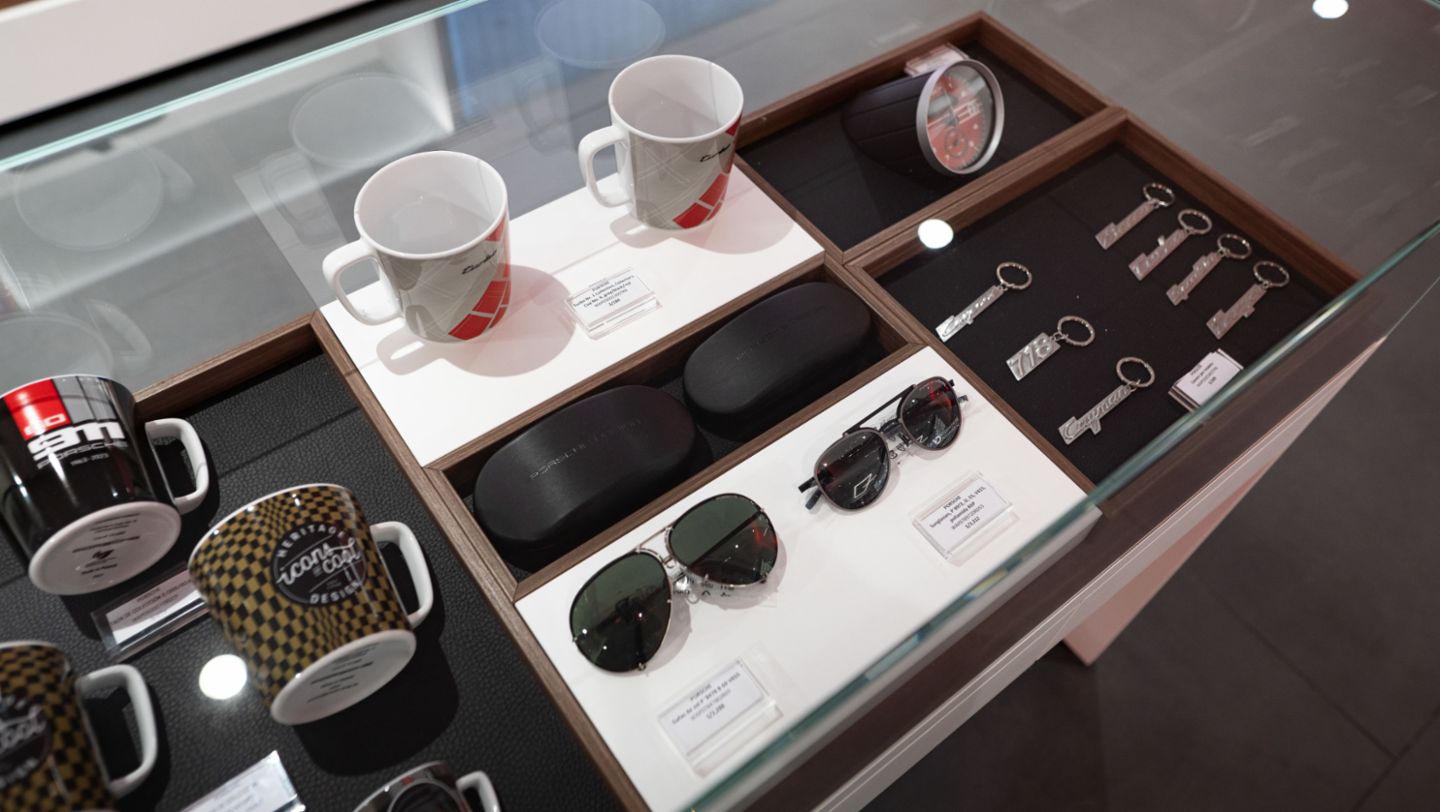 Gafas de sol, llaveros por modelos, taza de colección color verde negro de Heritage Design, y otros artículos de la nueva colección de Porsche Lifestyle que se presentó recientemente en el evento de Pilates Lifestyle Experience, Perú, Porsche AG.