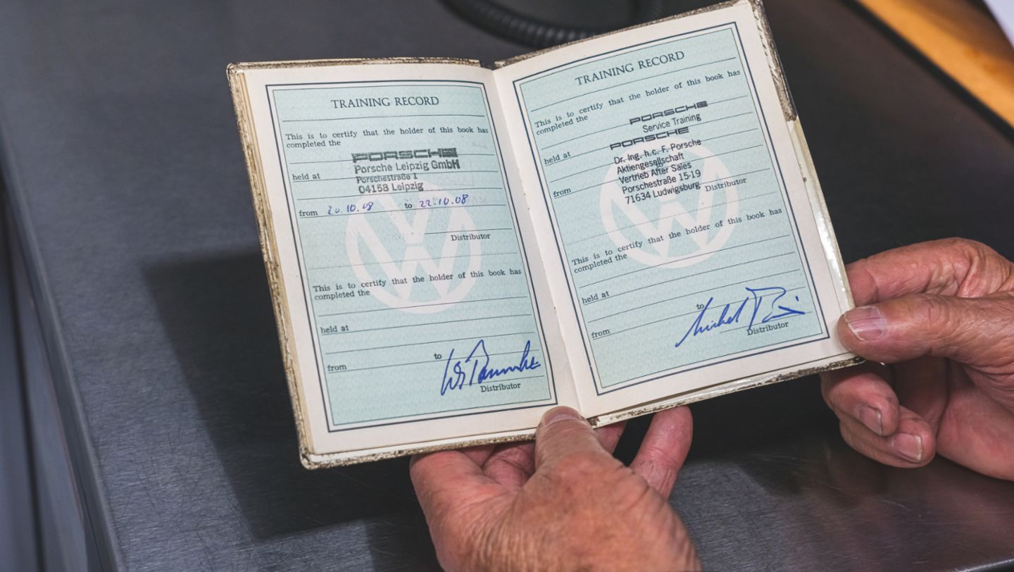 Jack Swint holds his original "training passport," Porsche Restoration Center, Atlanta, 2021, PCNA