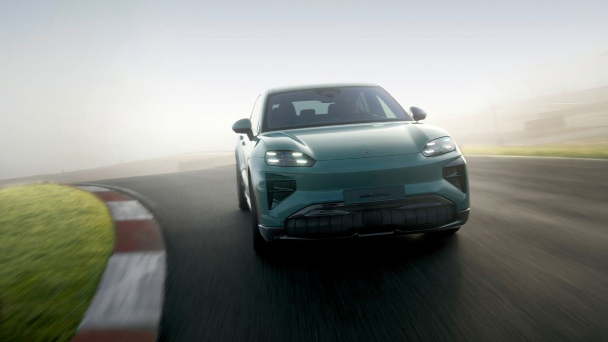 Ein grüner Porsche Cayenne fährt auf einer Rennstrecke.