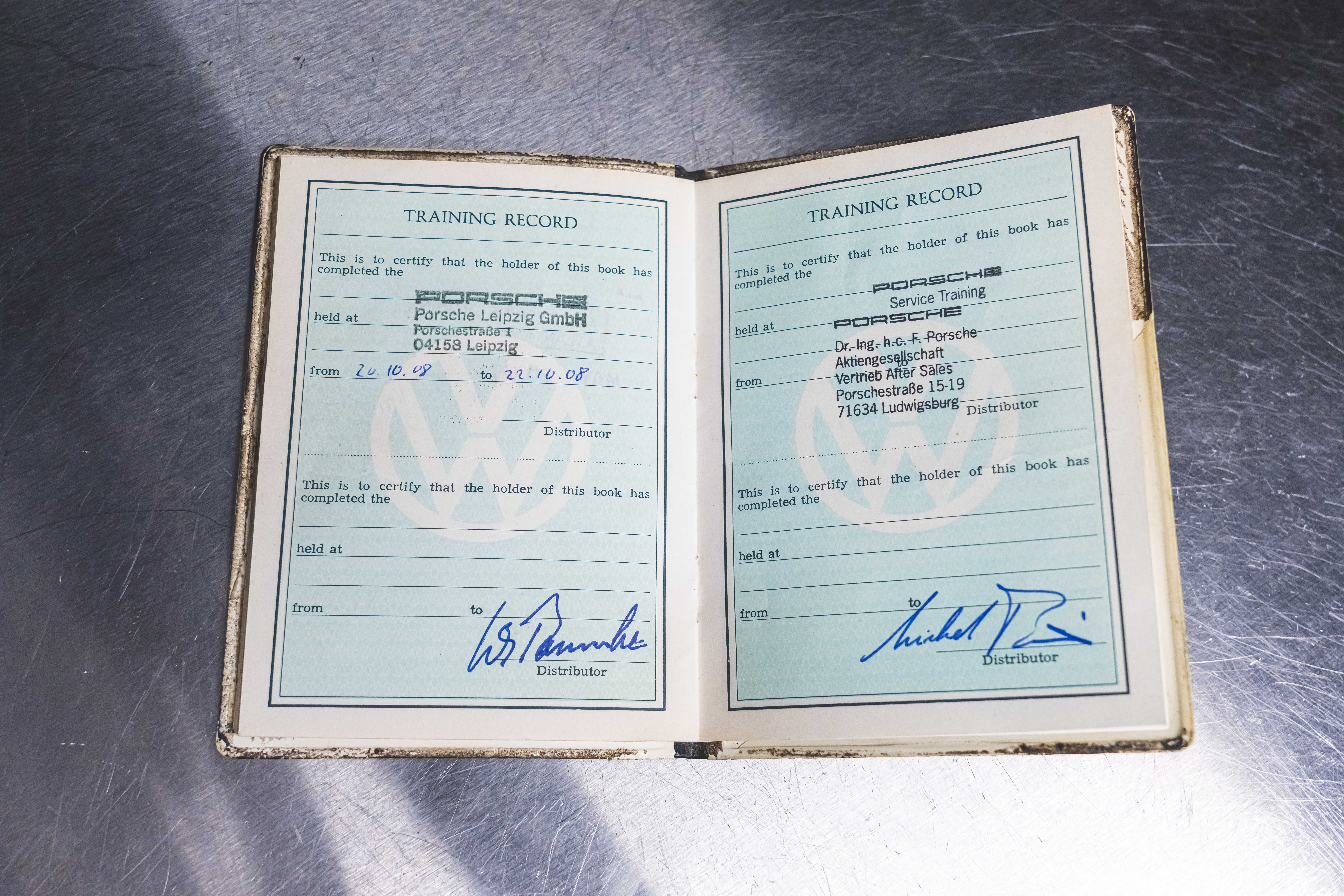 Jack Swint holds his original "training passport," Porsche Restoration Center, Atlanta, 2021, PCNA